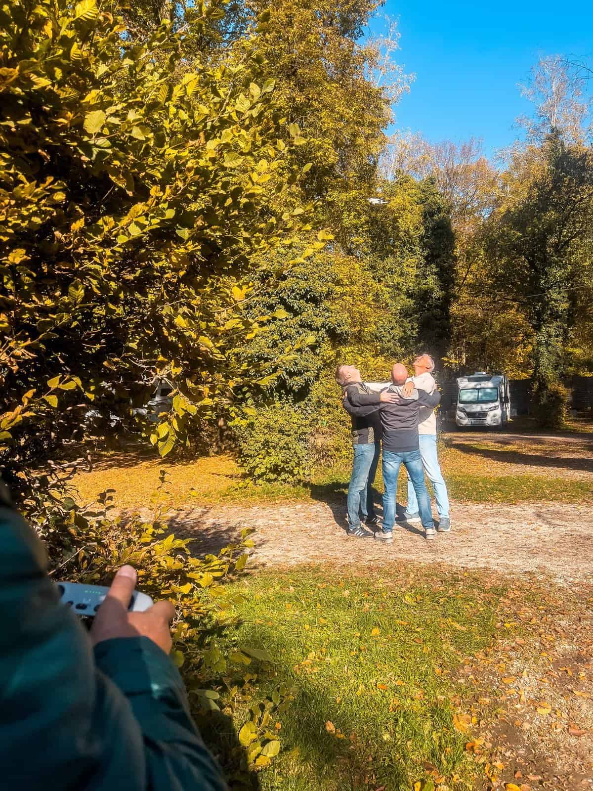 Das Team umarmt sich auf dem Campingplatz in der Herbstsonne