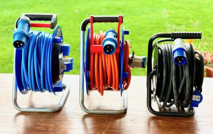 Drei Camping-Kabeltrommeln nebeneinander: Kalle das Kabel mit blauem, Brennenstuhl mit orangem und as Schwabe mit schwarzem Kabel