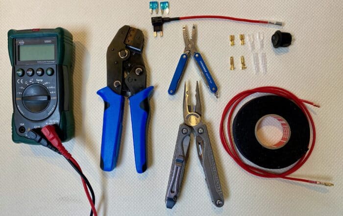 Werkzeug und Material fürs Dauerplus: Multimeter, Crimpzange, Sicherungsadapter, Kabelschuhe, Schalter und rotes Kabel