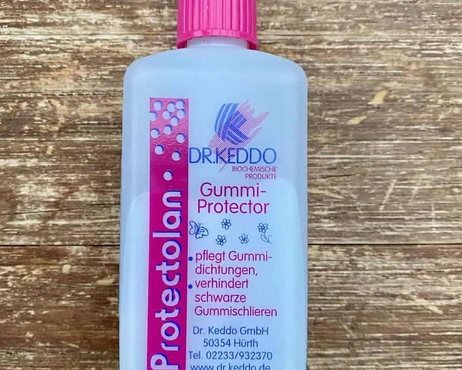 Dr. Keddo Protectolan Gummi-Protector, Flasche mit Etikett auf Holz