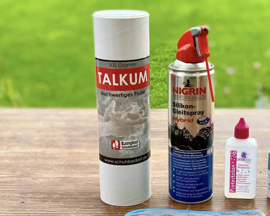 Talkum Puder 500 Gramm Dose auf Holztisch, daneben Nigrin Silikon-Gleitspray