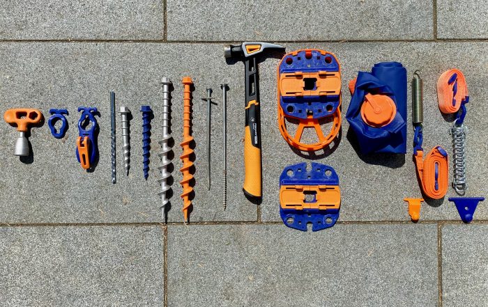 Peggy Peg Kombitool, Krokodilklemme, Bohrer, Schlag- und Schraubheringe aus Alu und Polyamid, Stahlnagel und Spax-Schraube nebeneinander