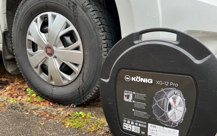 Schneekettenbox König XG-12 Pro neben dem Winterreifen des Wohnmobils