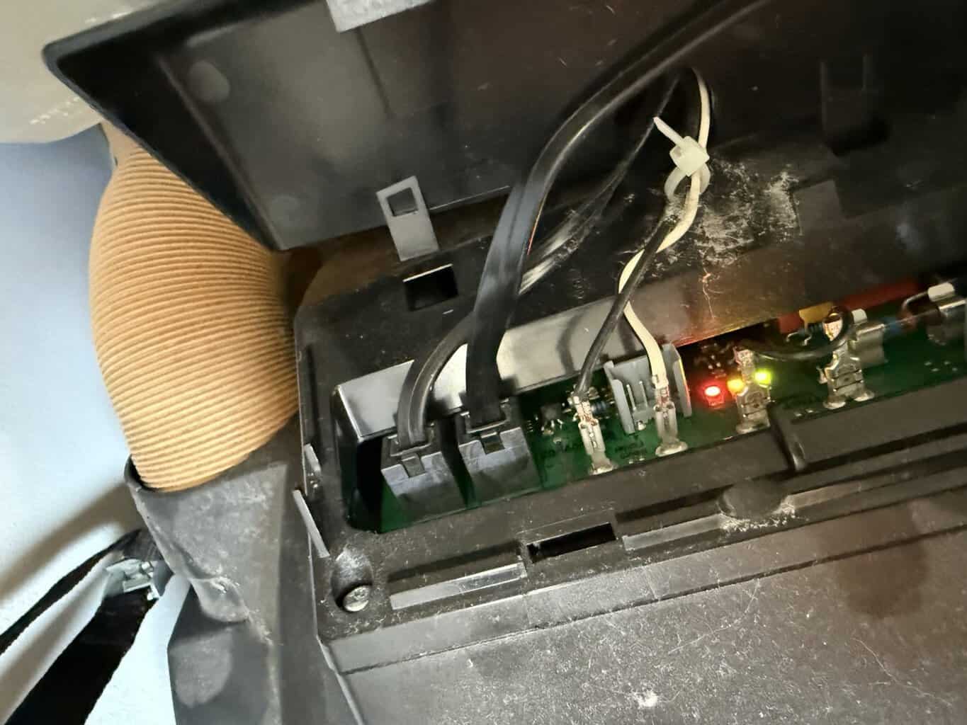 Geöffnete Klappe an der Truma Combi 6 mit Elektronik, 2 Steckern zum Bedienteil CP Plus, Kontroll-LEDs und Feinsicherung