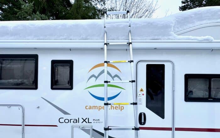 Teleskopleiter am Wohnmobil, Schnee wird vom Dach geräumt