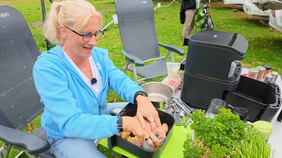 kartoffeln-druecken-07-034.5-kontrast Anke von Frag Mom! drückt am Campingtisch vorgekochte Kartoffeln in der Schublade des COSORI Airfryers platt