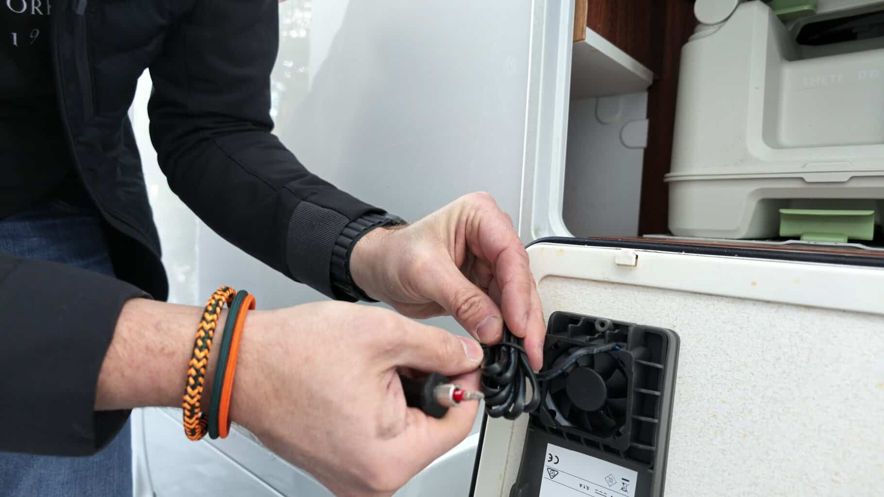 thetford-s260-luefter-kabel-anstecken Flo steckt das Kabel des Lüfters an der Innenseite der Service-Klappe an