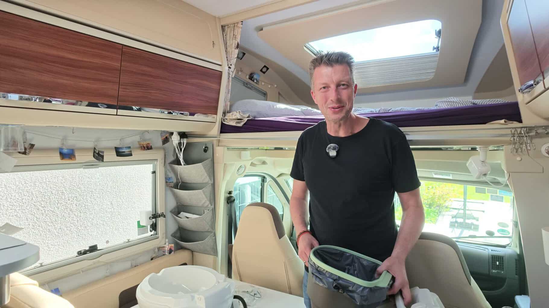 Flo im Wohnmobil mit dem Feststoffeimer der Thetford Trenntoilette S260 in der Hand